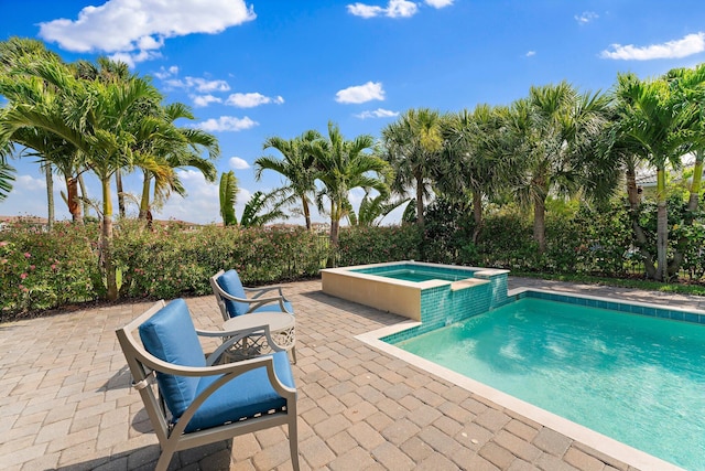 view of pool with a patio area and an in ground hot tub