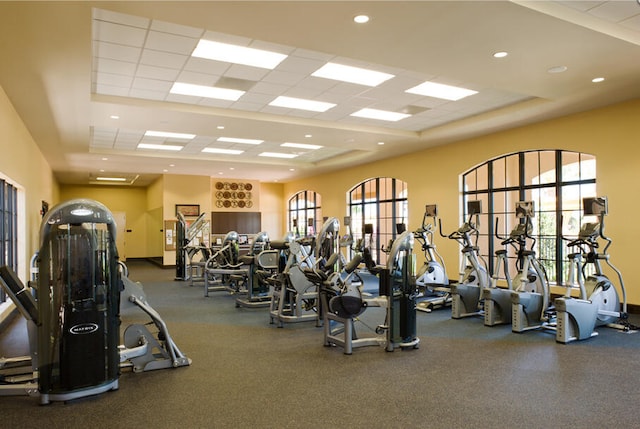 gym featuring a paneled ceiling and a tray ceiling