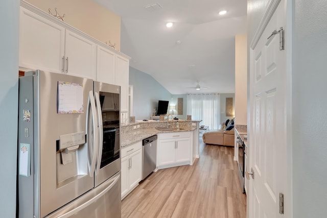 kitchen featuring ceiling fan, white cabinets, kitchen peninsula, appliances with stainless steel finishes, and vaulted ceiling