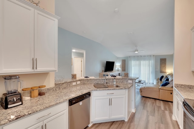 kitchen with appliances with stainless steel finishes, white cabinetry, light wood-type flooring, ceiling fan, and sink