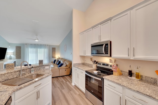 kitchen with white cabinets, lofted ceiling, light hardwood / wood-style flooring, appliances with stainless steel finishes, and ceiling fan