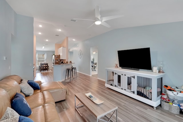 living room with light wood-type flooring, vaulted ceiling, and ceiling fan