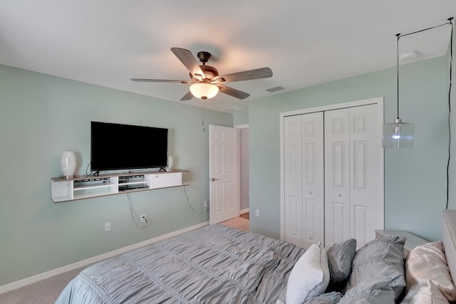 bedroom with ceiling fan, light colored carpet, and a closet