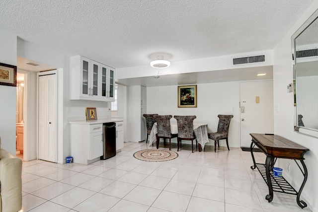 interior space with glass insert cabinets, visible vents, white cabinets, and light countertops