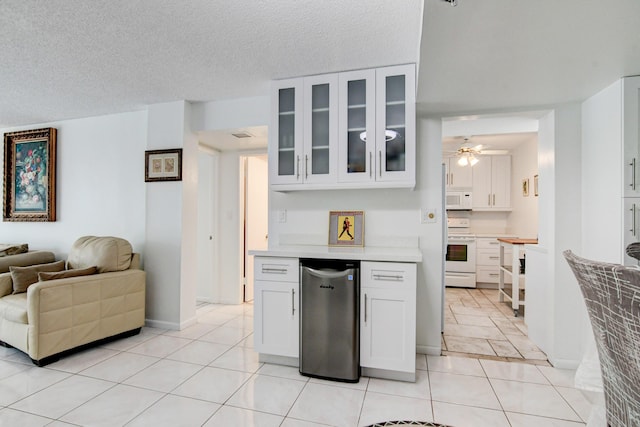 kitchen with glass insert cabinets, white appliances, light countertops, and white cabinetry