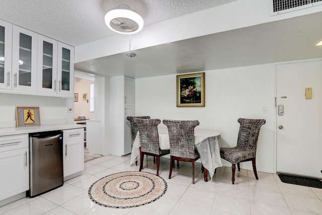 dining space featuring visible vents, a textured ceiling, and light tile patterned floors