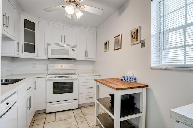 kitchen with a ceiling fan, white appliances, white cabinets, and glass insert cabinets