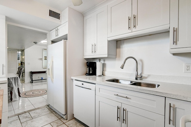 kitchen featuring white appliances, visible vents, light countertops, white cabinetry, and a sink