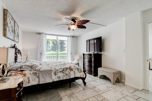 bedroom with a ceiling fan, a textured ceiling, and baseboards