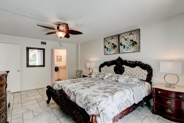 bedroom featuring a ceiling fan, visible vents, a textured ceiling, and ensuite bathroom