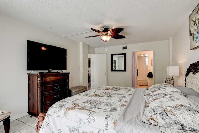 bedroom featuring ceiling fan, connected bathroom, visible vents, and a textured ceiling