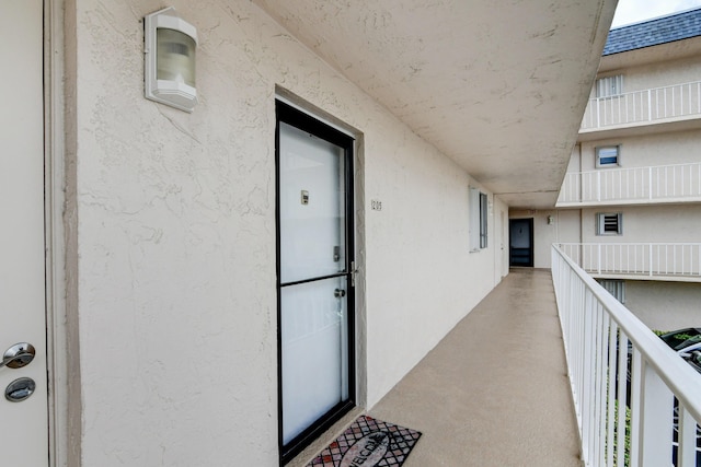 entrance to property with a balcony and stucco siding