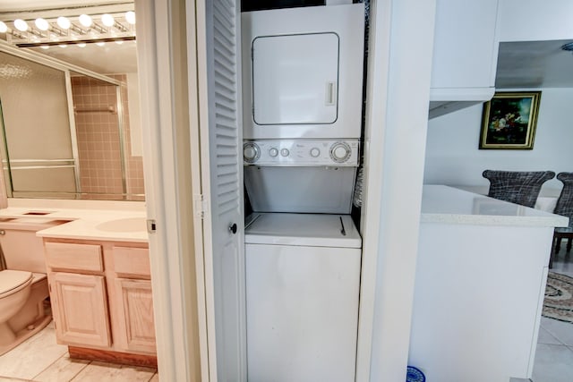 washroom with laundry area, light tile patterned floors, and stacked washer and clothes dryer