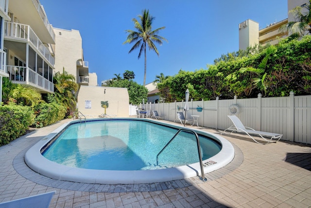 community pool featuring fence and a patio