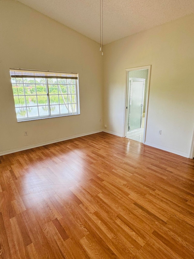 empty room with a textured ceiling and hardwood / wood-style floors