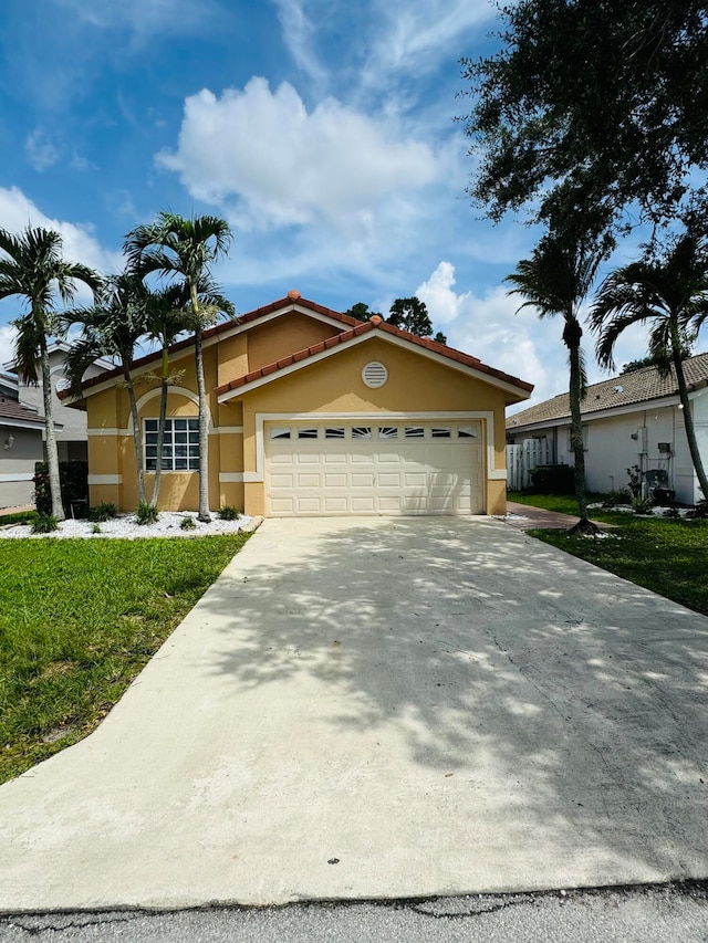 view of front of property with a garage and a front lawn