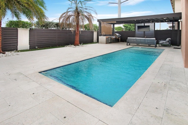 view of swimming pool featuring outdoor lounge area, a pergola, an outdoor kitchen, a patio, and grilling area