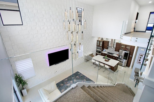 tiled living room featuring a towering ceiling and sink