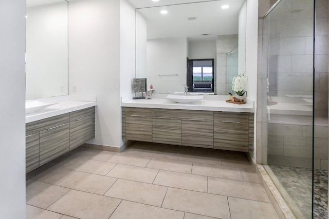 bathroom with tile patterned flooring, a tile shower, and vanity