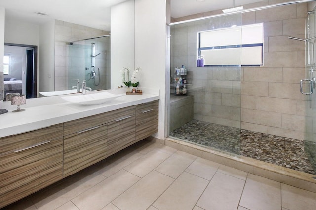 bathroom with tile patterned flooring, a shower with door, and vanity