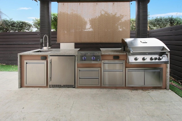 view of patio / terrace featuring area for grilling, sink, and an outdoor kitchen