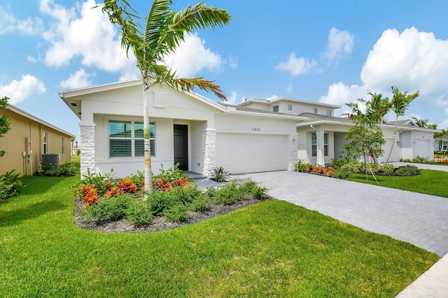 view of front facade featuring central AC unit, a garage, and a front lawn