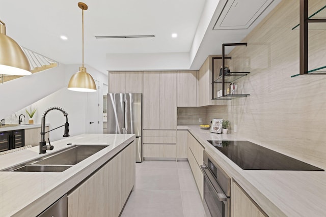 kitchen featuring light brown cabinetry, light tile patterned floors, appliances with stainless steel finishes, hanging light fixtures, and sink