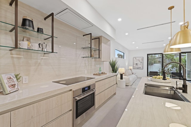 kitchen featuring light brown cabinetry, hanging light fixtures, sink, stainless steel oven, and black electric cooktop