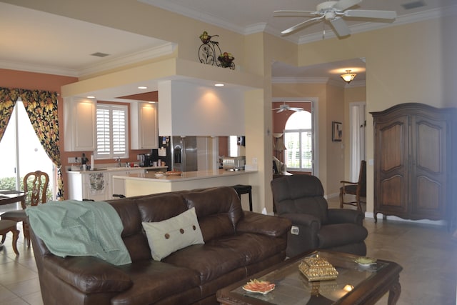 tiled living room with a wealth of natural light, ceiling fan, ornamental molding, and sink