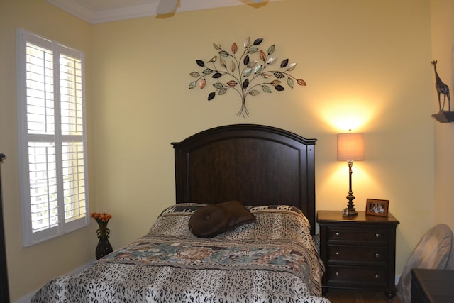 bedroom with ceiling fan and crown molding