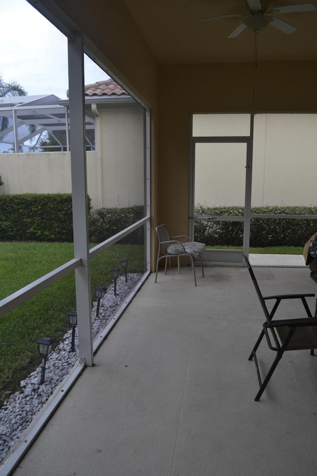 unfurnished sunroom with ceiling fan