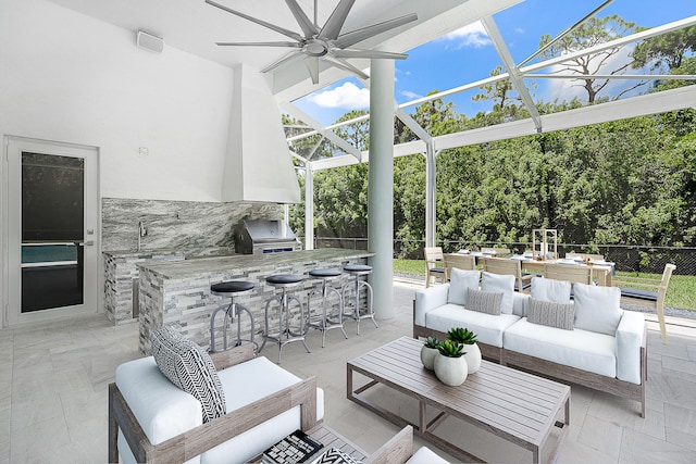 view of patio / terrace featuring ceiling fan, a grill, outdoor lounge area, an outdoor wet bar, and exterior kitchen