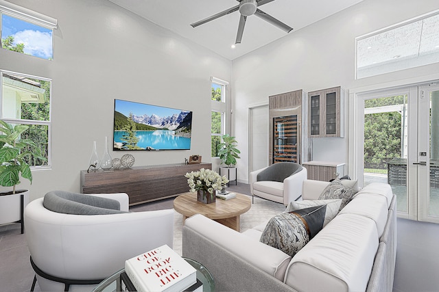 living room with a towering ceiling and ceiling fan