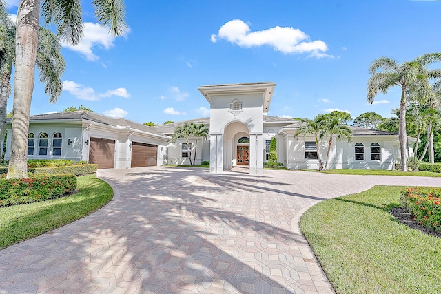 mediterranean / spanish house featuring a front lawn and a garage