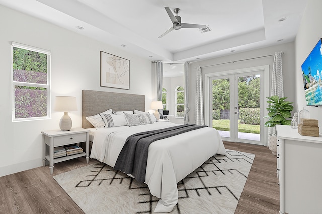 bedroom featuring light wood-type flooring, ceiling fan, a raised ceiling, access to outside, and french doors