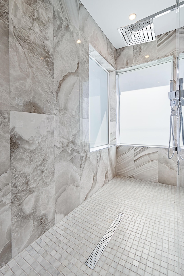 bathroom featuring tiled shower and tile walls