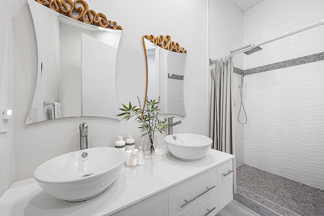 bathroom featuring walk in shower, hardwood / wood-style flooring, and vanity