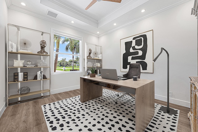 office with ornamental molding, a tray ceiling, dark hardwood / wood-style flooring, and ceiling fan