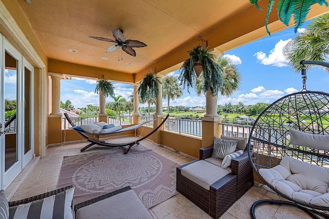 exterior space with a balcony, outdoor lounge area, a ceiling fan, and french doors