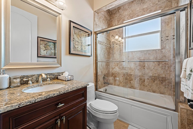 full bath featuring combined bath / shower with glass door, vanity, and toilet