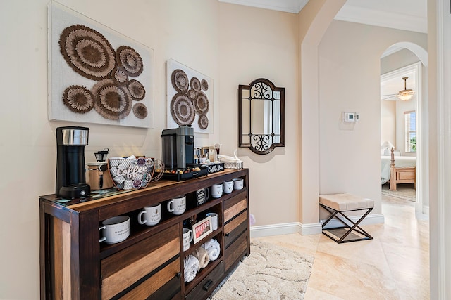 hallway featuring baseboards, arched walkways, and ornamental molding