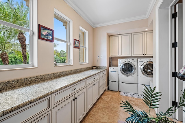 laundry area with cabinet space, crown molding, and separate washer and dryer