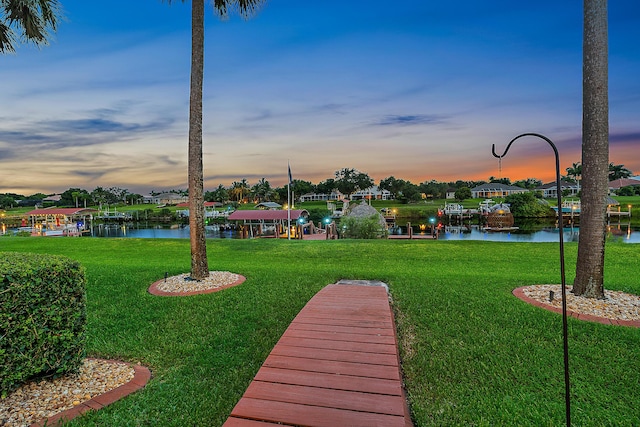 surrounding community with a yard and a water view