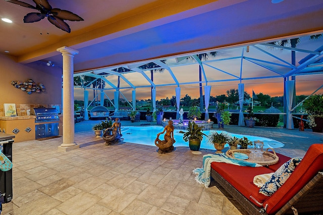 pool at dusk featuring a patio area, ceiling fan, area for grilling, and a lanai