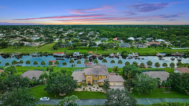 aerial view at dusk with a residential view and a water view