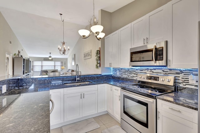 kitchen featuring sink, appliances with stainless steel finishes, a chandelier, light tile patterned floors, and lofted ceiling