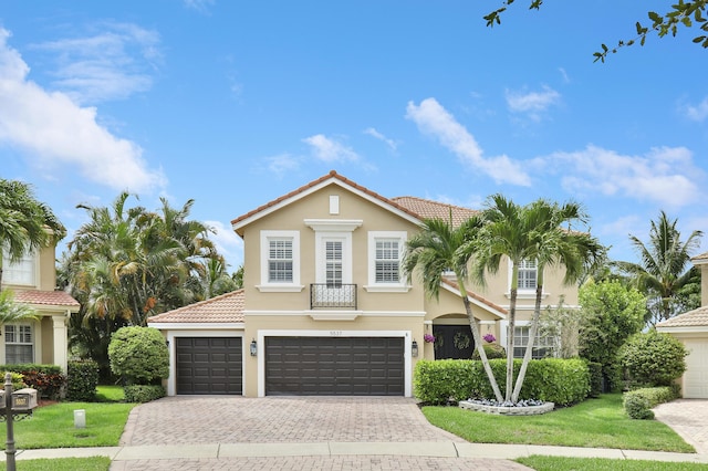 mediterranean / spanish house with a front lawn and a garage