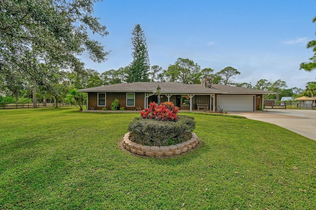 ranch-style home featuring a garage and a front lawn