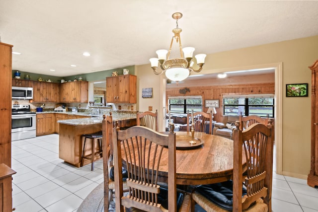 tiled dining area featuring an inviting chandelier