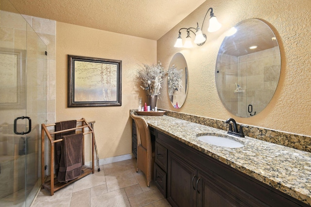 12390 Sandy Run, Jupiter, FL 33478 - bathroom with a textured wall, a shower stall, vanity, a textured ceiling, and stone tile floors